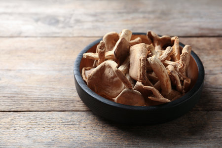 Plate of dried mushrooms on wooden background. Space for textの写真素材