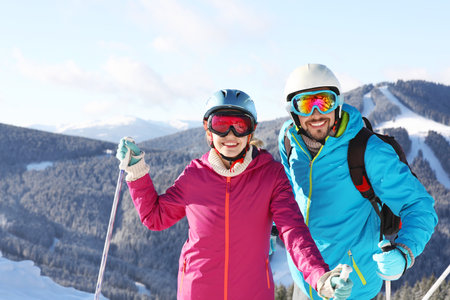 Couple with ski equipment spending winter vacation in mountainsの写真素材