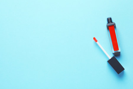 Applicator and liquid lipstick tube on color background, flat lay. Space for textの写真素材