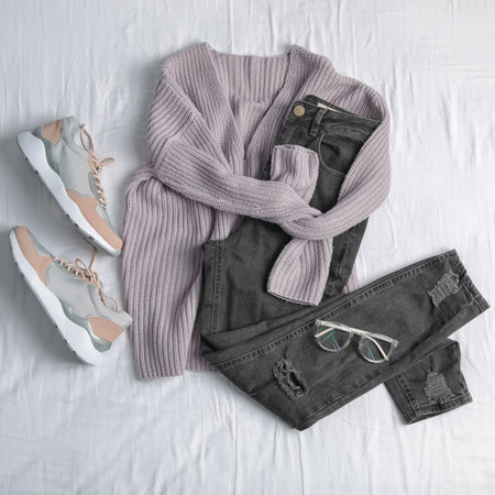 Flat lay composition with jeans, sweater and shoes on white fabricの写真素材