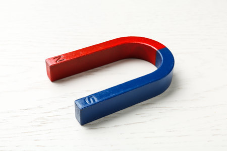 Red and blue horseshoe magnet on wooden background