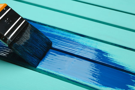 Brush and blue paint stroke on wooden background, closeup. Space for textの写真素材