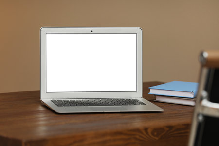 Laptop with blank screen on table indoors. Space for textの写真素材