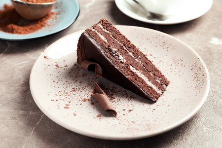 Plate with slice of tasty homemade chocolate cake on tableの写真素材