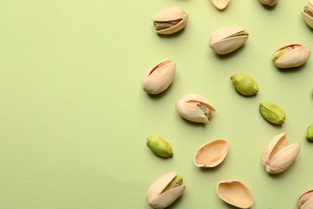Organic pistachio nuts on color background, flat lay. Space for textの写真素材