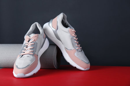 Composition of modern woman training shoes and mat on table. Space for textの写真素材