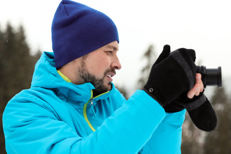 Man taking photo with camera outdoors. winter holidaysの写真素材