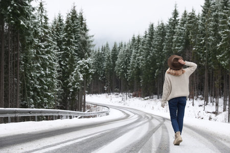 Young woman walking near snowy forest. winter holidaysの写真素材