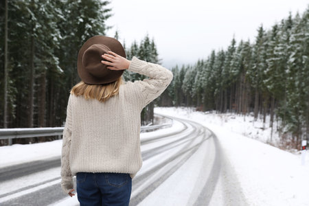 Young woman walking near snowy forest. winter holidaysの写真素材