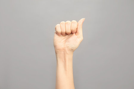 Woman showing A letter on gray background, closeup. sign languageの写真素材