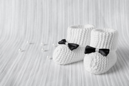Handmade baby booties on light plaid. Space for textの写真素材