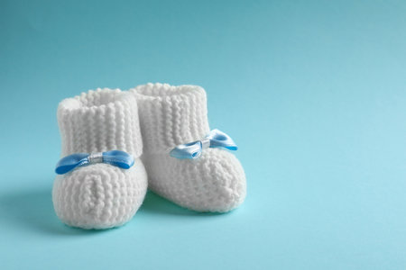 Handmade baby booties on color background. Space for textの写真素材
