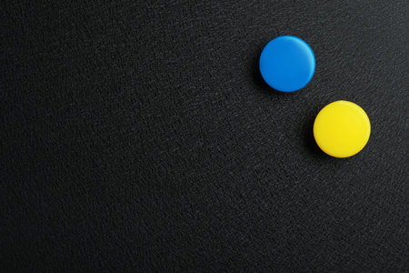 Bright magnets on black background, top view with space for textの写真素材