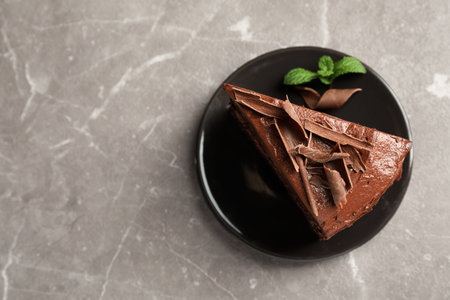 Plate with slice of tasty homemade chocolate cake and space for text on table, top viewの写真素材