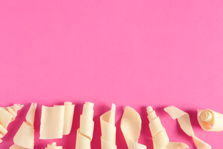 Yummy white chocolate curls and space for text on color background, top viewの写真素材