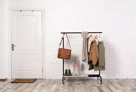 Stylish hallway interior with shoes and clothes on hanger standの写真素材