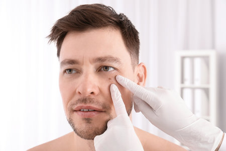 Doctor examining patient in clinic. Visiting dermatologistの写真素材