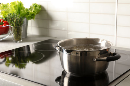 Pot with boiling water on electric stove in kitchen, space for textの写真素材