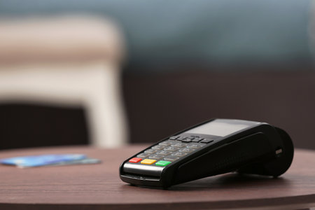 Modern payment terminal on table indoors. Space for textの写真素材