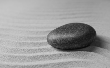 Zen garden stone on sand with pattern, space for text. meditation and harmonyの写真素材