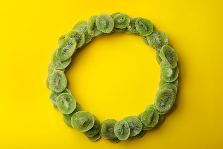 Frame made of kiwi on color background, top view with space for text. Dried fruit as healthy foodの写真素材