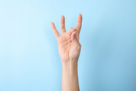 Woman showing number eight on color background, closeup. sign languageの写真素材