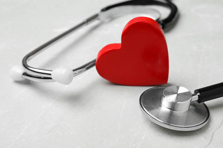 Stethoscope with red heart on light background, closeupの写真素材