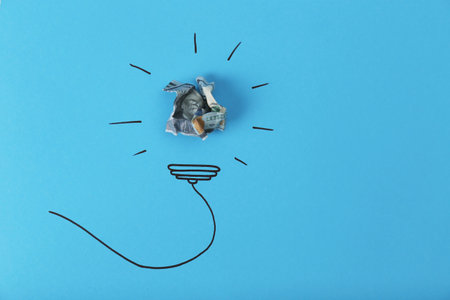 Composition with crumpled banknote, drawing of lamp bulb and space for text on color background, top view. creative conceptの写真素材
