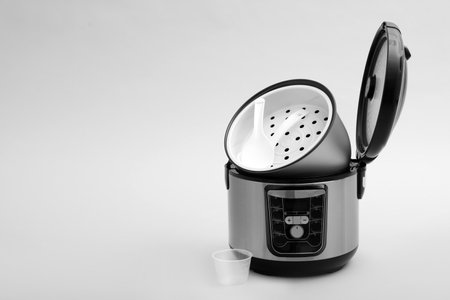Modern electric multi cooker, parts and accessories on gray background. Space for textの写真素材