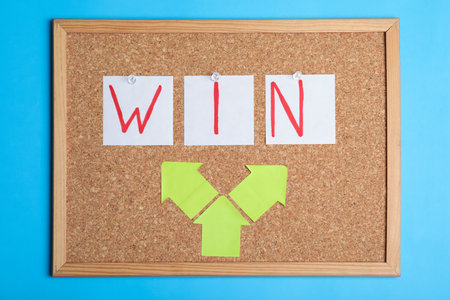 Cork board with notes forming word Win on color background. Victory conceptの写真素材