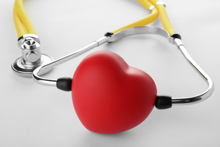 Red heart with stethoscope on white background, closeupの写真素材