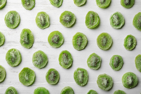 Slices of kiwi on wooden background, flat lay. Dried fruit as healthy foodの写真素材