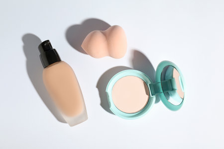 Skin foundation, powder and makeup sponge on white background, top viewの写真素材