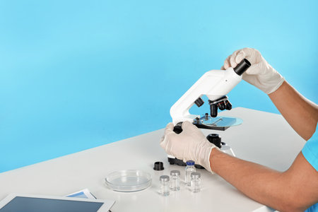 Male doctor using microscope at table, closeup with space for text. medical objectの写真素材