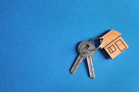 House keys with trinket on color background, top view. Space for textの写真素材