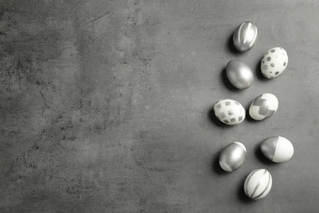 Painted Easter eggs on gray background, flat lay with space for textの写真素材