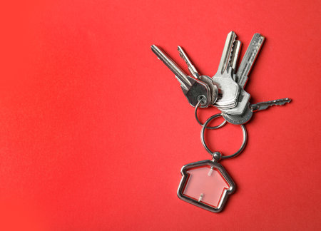 House keys with trinket on color background, top view. Space for textの写真素材