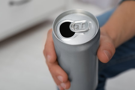 Man holding open aluminum can on blurred background, closeup. space for designの写真素材