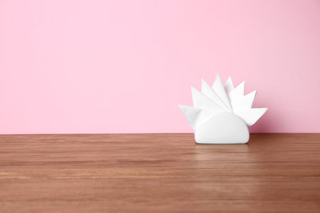 Napkin holder with paper serviettes on table against color background. Space for textの写真素材
