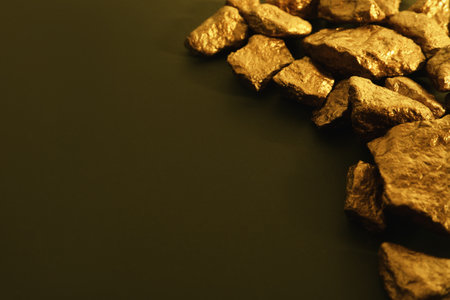 Pile of gold nuggets on color background. Space for textの写真素材