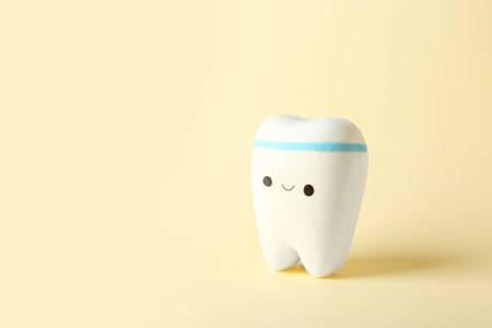 Model of tooth with happy face and space for text on color backgroundの写真素材