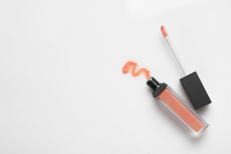 Beige liquid lipstick with smear and applicator isolated on white, top view. Space for textの写真素材