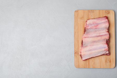 Board with raw ribs and space for text on gray background, top view. fresh meatの写真素材