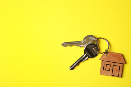 House keys with trinket on color background, top view. Space for textの写真素材