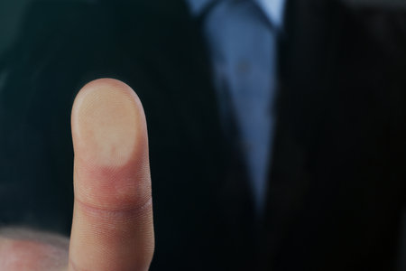 Businessman pressing control glass of biometric fingerprint scanner, closeup. Space for textの写真素材