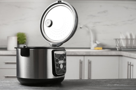 Modern multi cooker on table in kitchen. Space for text