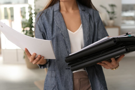 Businesswoman with folders and documents indoors, closeupの写真素材