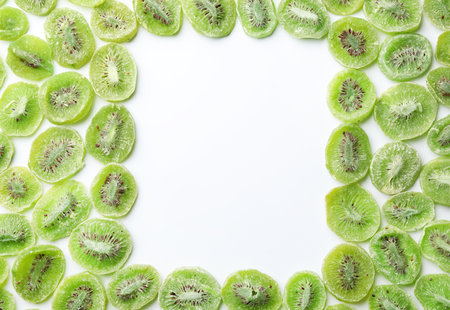 Frame made of kiwi on white background, flat lay. Dried fruit as healthy foodの写真素材