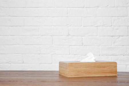 Napkin holder with paper serviettes on table against brick wall. Space for textの写真素材
