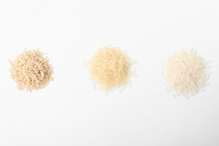 Different types of uncooked rice on white background, top viewの写真素材